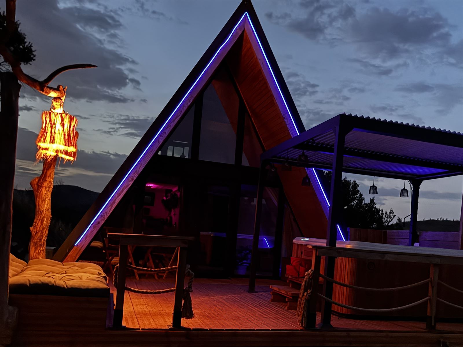 L'Amoré au crépuscule, façade soulignée de LED bleues et lampe sur pied sur la terrasse