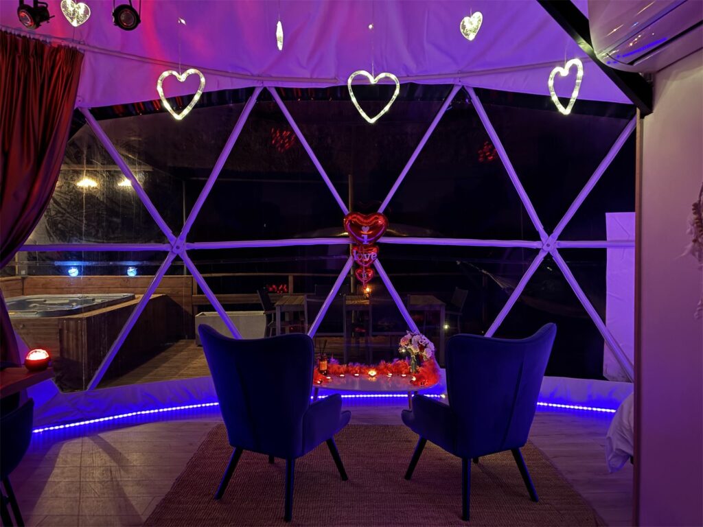 Intérieur du Dôme de la Tentation avec deux fauteuils bleus et une guirlande de cœurs lumineux