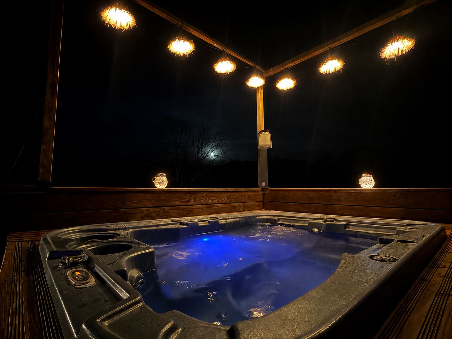 Jacuzzi privatif du Dôme de la Tentation éclairé de nuit sous des ampoules